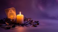 Mystical tarot cards with burning candle and crystals on purple cosmic background for fortune telling and spiritual guidance sessions.