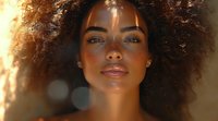 Young African American woman with natural curly afro hair illuminated by warm sunset light, glowing skin and serene expression, beauty portrait with bokeh effect.