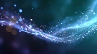 Magical glowing wave with sparkling particles and bokeh effects in deep blue and purple colors against dark background, creating ethereal cosmic atmosphere.