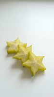 Fresh star fruit slices arranged on white background showing natural star shape cross-section with seeds visible for healthy eating and tropical cuisine.