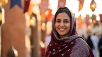 Young Middle Eastern woman wearing traditional headscarf smiling warmly in bustling marketplace with golden evening light and cultural atmosphere.