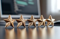 Five golden stars in a row on reflective surface with blurred background, representing excellence rating, quality review and achievement in business.