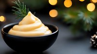 Creamy vanilla soft serve ice cream in black bowl with festive Christmas lights and pine branches creating warm holiday atmosphere for seasonal desserts.