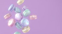 Colorful macarons falling through air on purple background, French pastry dessert cookies in pastel colors floating with motion blur effect.