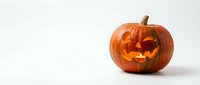 Carved orange pumpkin jack-o-lantern with glowing face on white background. Halloween decoration isolated for seasonal design and autumn projects.