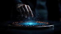 Futuristic holographic interface with glowing blue light and orange particles emerging from digital tablet, controlled by human hand in dark atmosphere.