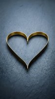 Two golden wedding rings arranged in heart shape on dark textured surface symbolizing love marriage commitment and romantic union for wedding concepts.