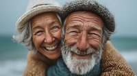 Happy elderly couple embracing on beach, senior man and woman smiling together, retirement lifestyle, love and companionship in golden years.