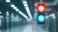 Traffic light with red and blue signals glowing in blurred urban tunnel environment with bokeh lights creating atmospheric mood for transportation safety concept.