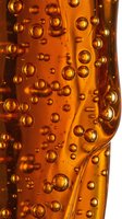 Carbonated beverage with bubbles and condensation on glass surface, suitable for beverage advertising and refreshment marketing campaigns.