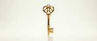 Ornate golden key with decorative crown-shaped head isolated on white background, suitable for luxury branding, success concepts, and design applications.