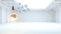 Glowing lightbulb with brain filament and floating business icons in modern white office space representing innovation and digital commerce solutions.