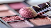 Makeup brush with pink powder blush palette showing soft bristles and shimmer particles in close-up macro photography, professional cosmetics and beauty products.