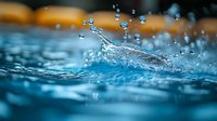 Dynamic water splash with floating droplets captured in macro photography against blurred blue background with orange accent, fresh pure liquid motion.