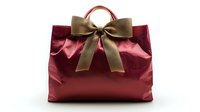 Elegant burgundy gift bag with golden ribbon bow isolated on white background for holiday shopping and present wrapping occasions.