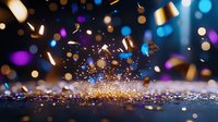 Magical explosion of golden confetti and glitter against dark background with blue and purple bokeh lights creating festive celebration atmosphere.