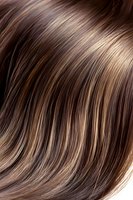 Close-up of glossy brown hair with caramel highlights showing smooth texture and natural shine, ideal for beauty and haircare advertising.