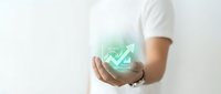 Young man in white shirt holding glowing virtual financial growth chart with rising arrow, symbolizing investment success and business analytics.