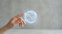 Hand reaching toward glowing circular hologram with swirling patterns against neutral background for futuristic technology concepts.
