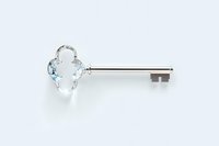 Crystal glass key with metal shaft on white background, isolated decorative object for luxury design and security concepts.