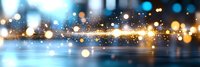Abstract blurred winter cityscape background with glowing golden bokeh lights and sparkles floating over frozen lake surface at dusk.