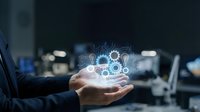 Business professional holding glowing digital network icons with gears and connections in modern office environment for technology presentations.