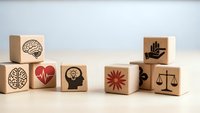 Wooden blocks with mental health and wellness icons including brain, heart, lightbulb, scales of justice and helping hand symbols on neutral background.
