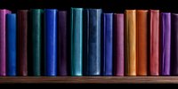 Row of colorful book spines arranged on wooden shelf against black background, showcasing vibrant blues, teals, oranges and purples in panoramic composition.