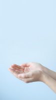 Open cupped hands gesture on light blue background showing care, support and receiving concept for wellness and spiritual themes.