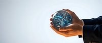Businessman holding glowing crystal ball with digital tree network inside, symbolizing innovation, future technology, and business growth strategy for corporate solutions.