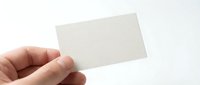 Hand holding blank white business card mockup against clean background for branding and corporate identity design projects.