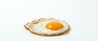 Fried egg with crispy golden brown edges on white background, isolated and ready for food, cooking, and recipe design use.