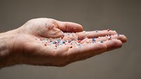 Hands holding colorful pharmaceutical pills and capsules for medical treatment and healthcare concept on neutral background.