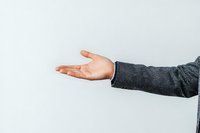 Male hand in gray business suit sleeve extending with open palm against white background, offering gesture for business and presentation concepts.