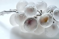 Frozen grapes covered in ice crystals on white background, winter fruit concept for culinary and beverage applications.