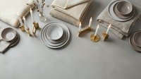 Elegant neutral tableware and kitchen accessories arranged on marble surface for modern home styling and culinary presentation needs.
