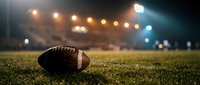 American football on grass field with stadium lights creating dramatic sports atmosphere for game night and athletic competition.