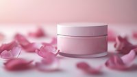 Pink cosmetic cream jar surrounded by delicate rose petals on soft pink background, creating luxurious skincare product presentation for beauty and spa marketing.