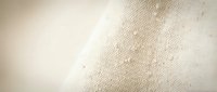 Natural beige linen fabric texture with soft lighting and gentle folds, perfect for backgrounds, textile design, and organic material concepts.