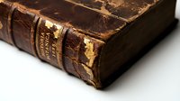 Antique leather-bound book with worn brown cover and gold embossed spine detail, showcasing aged texture and vintage craftsmanship for historical, literary, and nostalgic design projects.