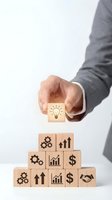 Businessman hand placing lightbulb block on wooden cubes with business icons representing innovation, growth and success concepts for strategy.