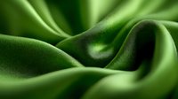 Smooth waves of luxurious green silk fabric create elegant folds and curves with soft shadows, showcasing rich texture and flowing movement. Macro photography.