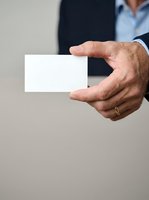 Mature Caucasian male professional in business attire holding blank white card, suitable for corporate branding, business card mockups, and marketing presentations.