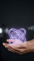 Hands holding glowing purple holographic atomic structure with orbital rings floating above palm in dark environment for science technology concepts.