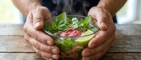 Hands holding a refreshing mojito cocktail with fresh mint leaves and lime on wooden surface, perfect for beverage, bartending, and summer drink concepts.