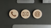 Contact us icons on wooden circles, phone mail and email symbols for business communication and customer service.