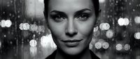 Young woman portrait with city lights bokeh background in black and white monochrome style for commercial photography and advertising campaigns.