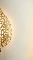 Elegant golden ornamental leaf with intricate floral scrollwork on cream background for luxury design projects and decorative applications.