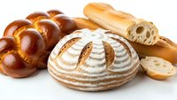 Fresh artisan bread collection with sourdough loaf, braided challah and baguette slices isolated on white background for bakery and food design projects.