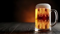Fresh golden beer mug with foam on wooden table against warm brown background for brewery advertising and beverage marketing campaigns.